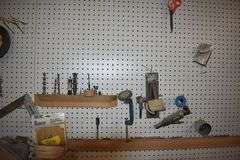 CONTENTS ON WORKBENCH AND PEG BORAD INCLUDING EAR PROTECTION, WRENCHES, SAWS AND CLAMPS
