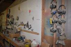 CONTENTS ON WORKBENCH AND PEG BORAD INCLUDING EAR PROTECTION, WRENCHES, SAWS AND CLAMPS