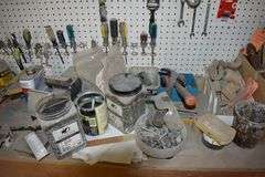 CONTENTS ON WORKBENCH AND PEG BORAD INCLUDING EAR PROTECTION, WRENCHES, SAWS AND CLAMPS