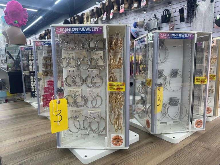 Lot of (4) Tabletop Rotating Display Cases w/ Locking Plexiglass Doors. Includes Fashion Jewelry Including Earrings and Necklaces. Cases Measure 12” X 12” X 21”. These are screwed to shelf, screwdriver or drill required for removal. Single Key fits all (4) Cases