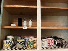 Lot of 16 mugs, salt and pepper shaker)located in kitchen )