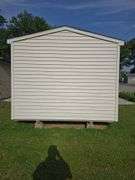 Portable shed 12'3"x10'3" 9' tall, 36"x80" door, on runners, buyers must remove