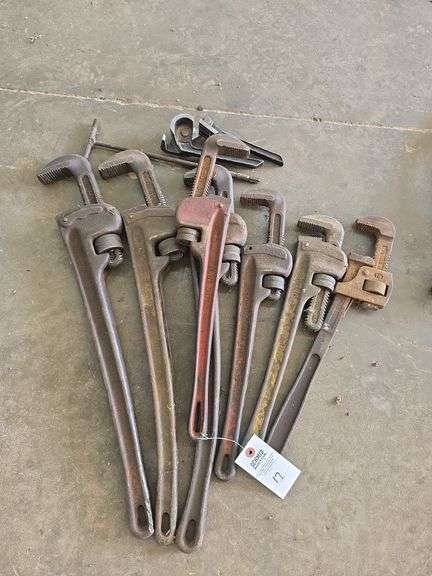 Large assortment of pipe wrenches.