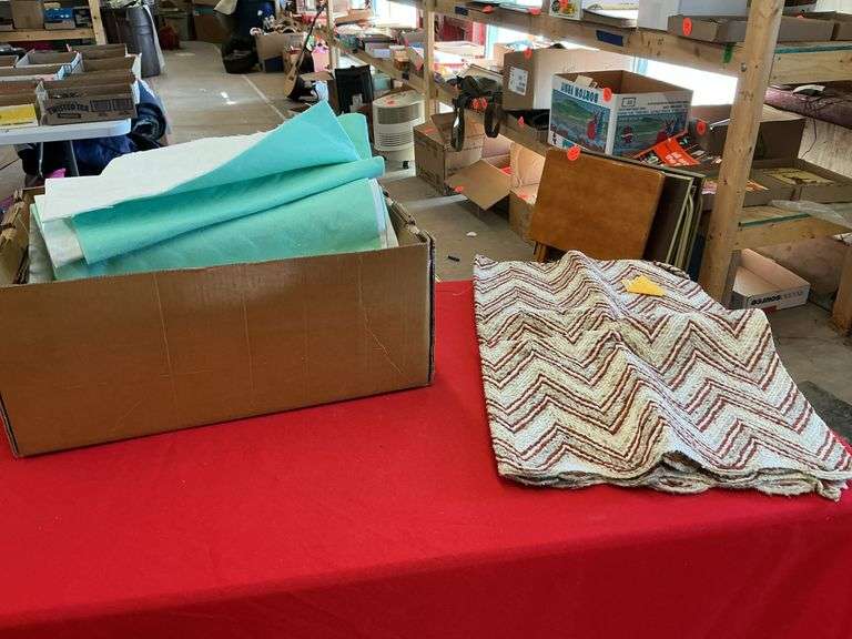 box of material with backing on it and a textured printed throw rug ...