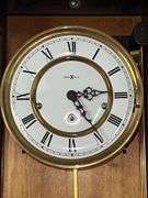 Howard Miller Oak Regulator Wall Clock (32”T,10.5”L,7”D)