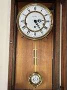 Howard Miller Oak Regulator Wall Clock (32”T,10.5”L,7”D)