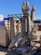 Metal frame palette with assorted patio umbrellas and throw rugs ...