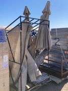 Metal frame palette with assorted patio umbrellas and throw rugs ...