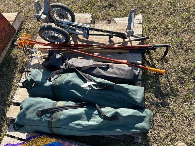 Pallet with ski poles, golf cart and folding chairs