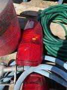Pallet with garden hose, fuel nozzle hose, tail lights, and gas can