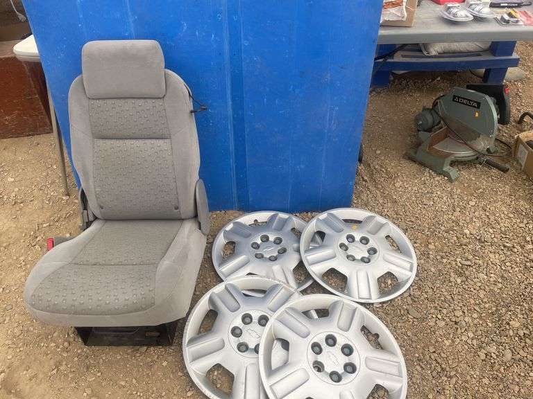 4 Chevy hubcaps and a bucket seat