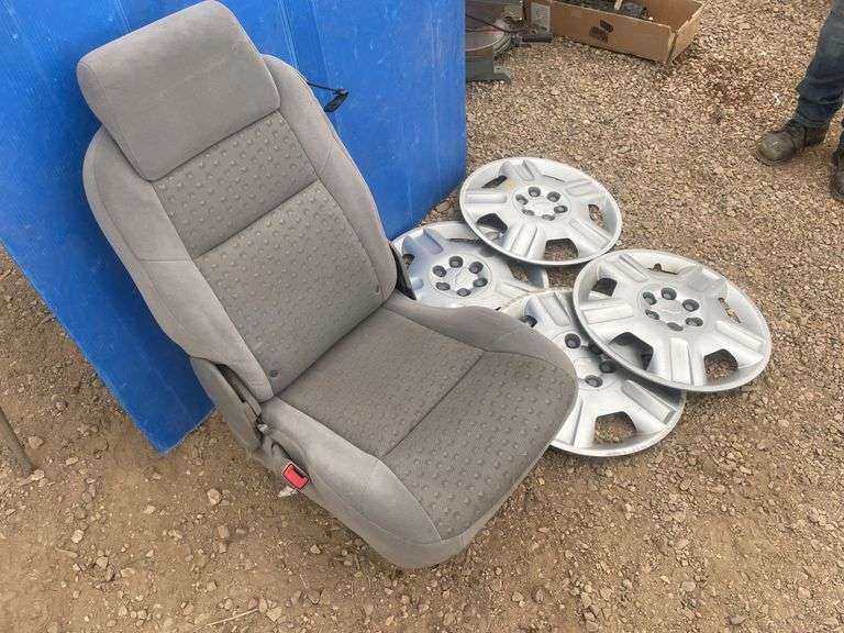 4 Chevy hubcaps and a bucket seat