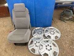 4 Chevy hubcaps and a bucket seat