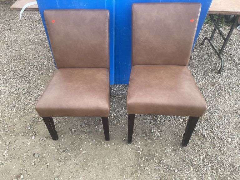 A pair of  brown upholstered chairs one chair has one leg repaired