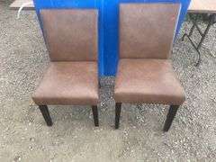A pair of  brown upholstered chairs one chair has one leg repaired