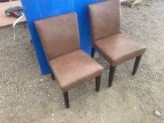 A pair of  brown upholstered chairs one chair has one leg repaired
