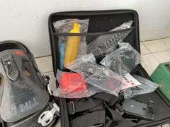 Pair of snowboarding bindings, gears, handlebar bag, Coleman camp stove, garment bag, miscellaneous