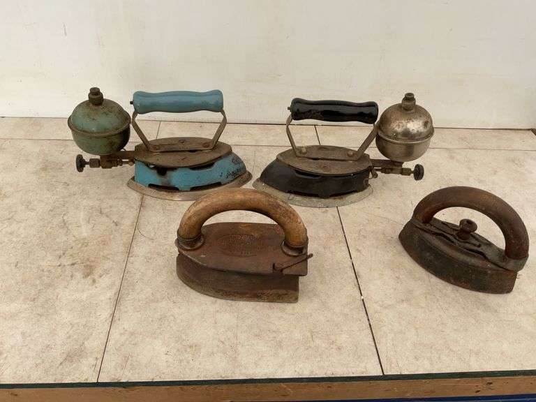 A pair of gas irons, one sad  iron, one self heating (imperial iron), elec iron, kerosine lamp