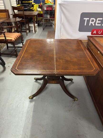 Game table. Leather top. 35x35in. Swivels. Storage underneath. On wheels.