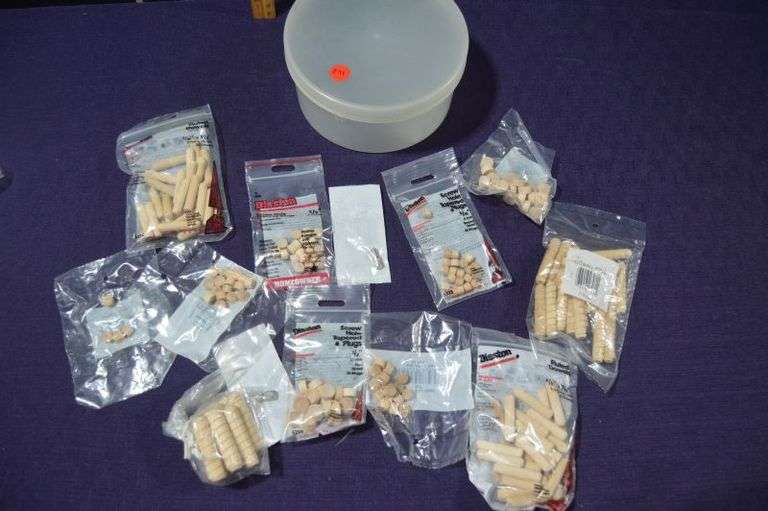 CONTAINER OF DOWELS & SCREW HOLE COVERS. A FEW BAGS OPENED W/MISSING PIECES