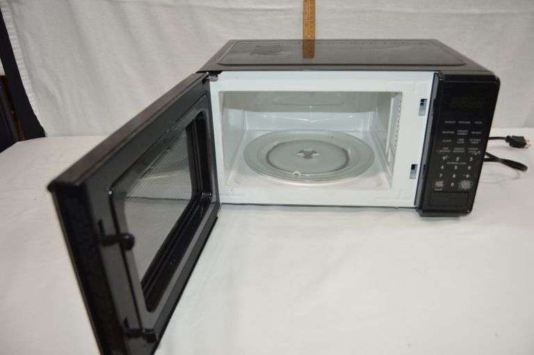 SMALL WALMART MICROWAVE. THERE IS A DENT IN THE BACK, BUT IT WORKS