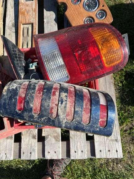 Crate w/ Fan Clutch, Heater Motor, GMC Hord Cover, Door Handle & Misc Plastic Trim, 1 - Crate w/ Taillights 2 - Ford Truck & 2 - Chevy Truck, 80's Datsun Custom Dash w/ Gauges & Switch Panel, 1 - Box w/ Misc. Cords, Saw Blade, & Lens Covers *Unreserved*