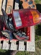 Crate w/ Fan Clutch, Heater Motor, GMC Hord Cover, Door Handle & Misc Plastic Trim, 1 - Crate w/ Taillights 2 - Ford Truck & 2 - Chevy Truck, 80's Datsun Custom Dash w/ Gauges & Switch Panel, 1 - Box w/ Misc. Cords, Saw Blade, & Lens Covers *Unreserved*