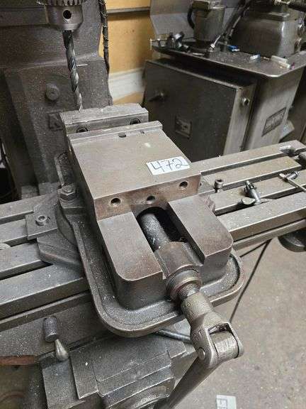 6" METAL MILLING MACHINE VISE APROX 17"L MOUNTED TO MACHINE, BRING TOOL TO REMOVE