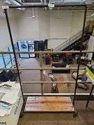 RUSTIC CUSTOM MADE ROLLING CLOTHING RACK WITH METAL PIPE SUPPORTS AND SOLID WOOD SHELVES APROX 40"x16"x68"
