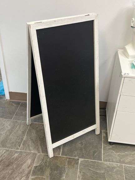 A-frame sidewalk sign features a double-sided black chalkboard surface framed in distressed white wood