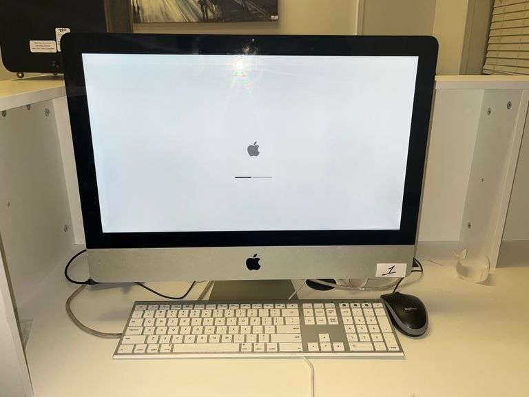 Apple iMac 21.5-inch desktop computer with a white keyboard and Logitech mouse on a desk. The 21.5-inch iMac was part of Apple's Intel-based lineup, offering a 4K Retina display