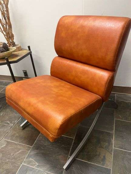 Modern brown leather and chrome chair with a sleek, minimalist design.loading…