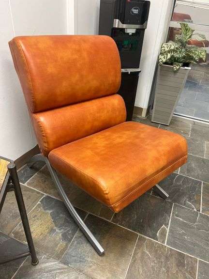 Modern brown leather and chrome chair with a sleek, minimalist design.loading…