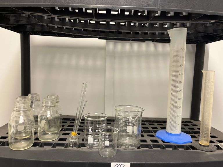 Lot of assorted laboratory glassware made of borosilicate, incld. beakers, graduated cylinders, and storage bottles. Count 12