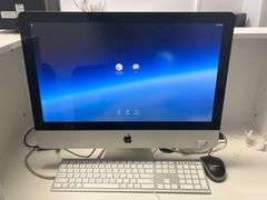 Apple iMac 21.5-inch desktop computer with a white keyboard and Logitech mouse on a desk. The 21.5-inch iMac was part of Apple's Intel-based lineup, offering a 4K Retina display