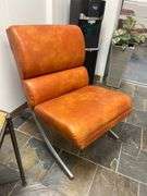 Modern brown leather and chrome chair with a sleek, minimalist design.loading…
